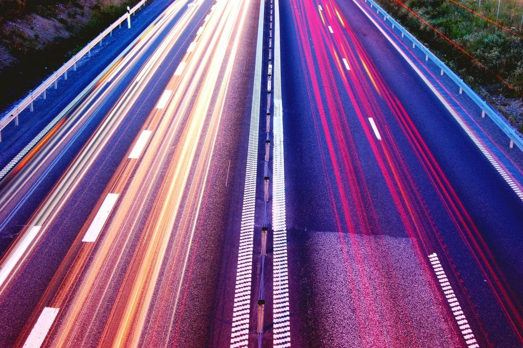 L'immagine mostra un'autostrada, le luci sono sfocate. Non si vedono auto, la velocità deve essere rappresentata.