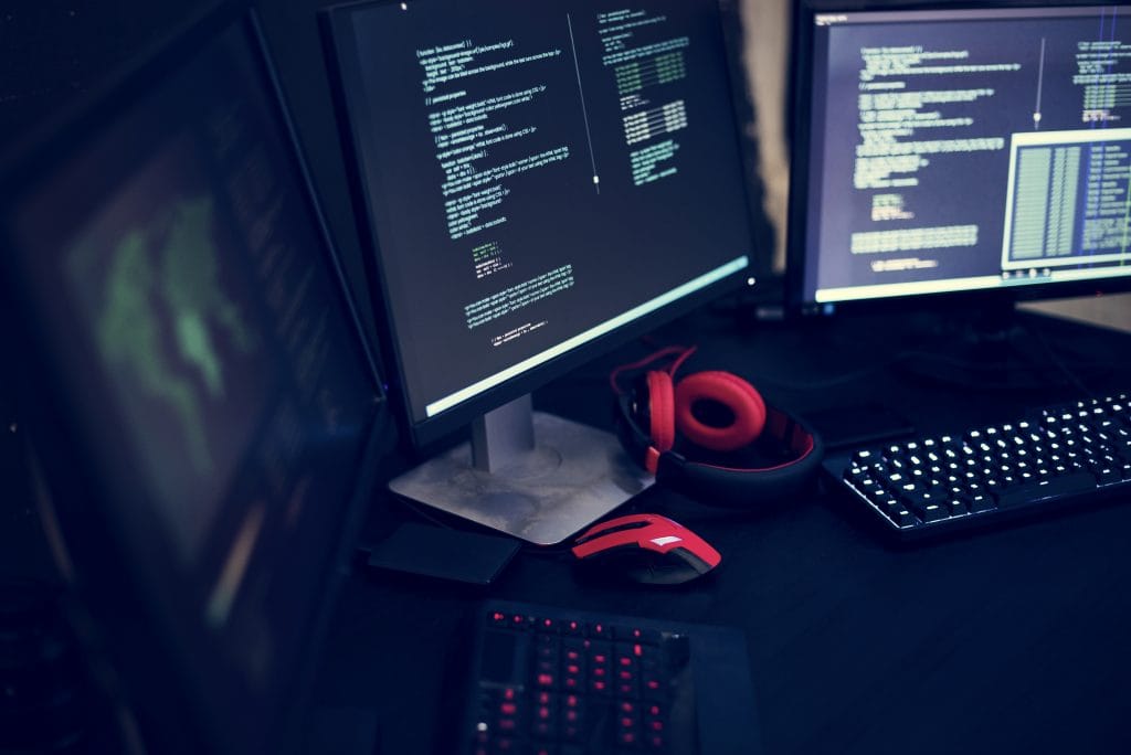 This picture shows a desk with many screens in a cool atmosphere.