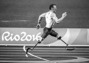 Homem com próteses nas pernas corre na pista