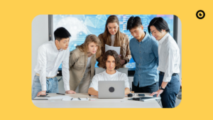 Interested people stand in front of a laptop.