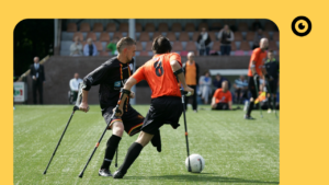 Una persona con muletas jugando al fútbol.